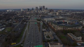 AX0171_0158 - 6.7K aerial stock footage tilt from freeway to reveal Downtown Atlanta skyline at sunset, Georgia