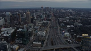 AX0171_0183 - 6.7K aerial stock footage tilt from freeway to reveal Midtown and Downtown Atlanta at sunset, Georgia