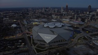 AX0171_0195 - 6.7K aerial stock footage of circling Mercedes-Benz Stadium at sunset in Downtown Atlanta, Georgia