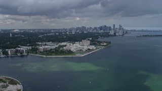AX0172_015 - 6.7K stock footage aerial video flyby Grove Isle condo complexes toward Downtown Miami, Florida, for view of hospital