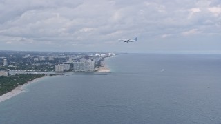 AX0172_040 - 6.7K aerial stock footage of a commercial airplane flying over the water toward Fort Lauderdale, Florida