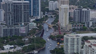 AX0172_047 - 6.7K aerial stock footage of boats sailing the New River toward a bridge in Fort Lauderdale, Florida