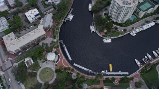 AX0172_057 - 6.7K aerial stock footage tilt to bird's eye of a ferry sailing toward a dock and New River in Downtown Fort Lauderdale, Florida