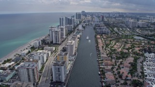 AX0172_070 - 6.7K aerial stock footage tilt from canal to reveal and pass condos in Hollywood, Florida