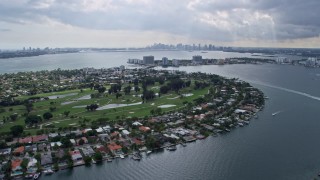 AX0172_075 - 6.7K stock footage aerial video a view of the Miami skyline seen from Miami Beach golf course and waterfront homes, Florida