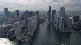 AX0172_107 - 6.7K stock footage aerial video of following the Miami River past waterfront skyscrapers in Downtown Miami, Florida