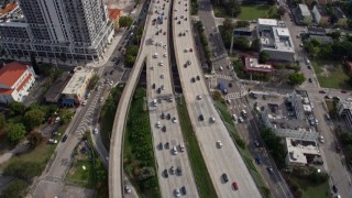 AX0172_112 - 6.7K aerial stock footage tilt from heavy traffic on I-95, reveal tall skyscrapers in Downtown Miami, Florida