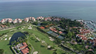 AX0172_127 - 6.7K aerial stock footage of flying over the golf course of Fisher Island near oceanfront condo complexes, Miami, Florida