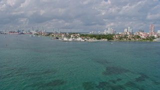 AX0172_128 - 6.7K stock footage aerial video of approaching Fisher Island's oceanfront condo complexes, Miami, Florida