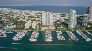 AX0172_130 - 6.7K aerial stock footage tilt from bay to reveal and fly over condo complex, South Beach, Miami, Florida