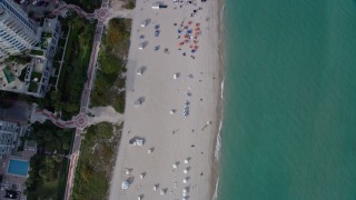 AX0172_135 - 6.7K aerial stock footage a view of a bird's eye view of sunbathers in South Beach, Miami, Florida