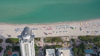AX0172_139 - 6.7K aerial stock footage of sunbathers on the beach in Miami Beach, Florida
