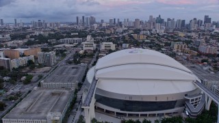 AX0172_181 - 6.7K aerial stock footage flyby stadium in Little Havana and reveal downtown skyline at sunset, Miami, Florida