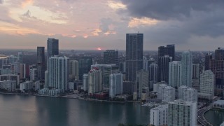 AX0172_187 - 6.7K stock footage aerial video of the setting sun behind waterfront skyscrapers in Downtown Miami, Miami, Florida