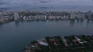 AX0172_194 - 6.7K aerial stock footage tilt from Biscayne Bay to reveal and approach Miami Beach at sunset, Miami, Florida
