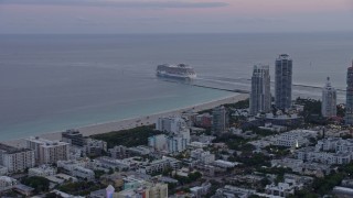 AX0172_195 - 6.7K aerial stock footage a cruise ship sailing near South Beach at sunset, Miami, Florida