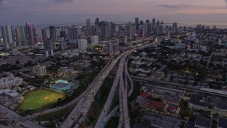 AX0172_203 - 6.7K stock footage aerial video of the Downtown Miami skyline seen from I-95 at twilight, Florida