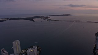 AX0172_206 - 6.7K aerial stock footage tilt from Downtown Miami skyscrapers to reveal Rickenbacker Causeway at twilight, Florida