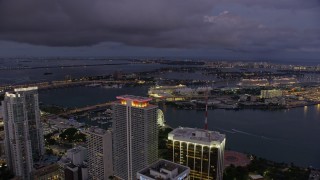 AX0172_213 - 6.7K aerial stock footage of flying over skyscrapers in Downtown Miami toward port and Jungle Island at twilight, Florida