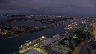AX0172_214 - 6.7K aerial stock footage of pan from Jungle Island to cruise ships at Port of Miami at twilight, Florida