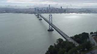 AX0173_0032 - 6K aerial stock footage tilt from traffic on the Bay Bridge to reveal Downtown San Francisco skyline, California