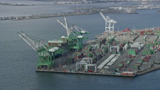 AX0173_0131 - 6K aerial stock footage of passing cargo cranes and ship at the Port of Oakland, California