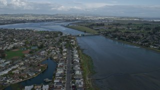 AX0173_0135 - 6K aerial stock footage fly over waterfront homes in Alameda toward Oakland Airport, California
