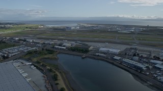 AX0173_0137 - 6K aerial stock footage of flying past runways and hangars at Oakland Airport, California