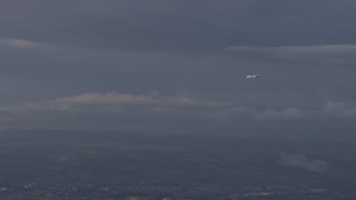 AX0174_0009 - 6K aerial stock footage of a commercial plane in flight over Hayward, California