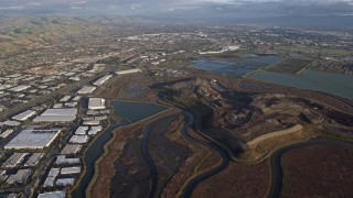 AX0174_0017 - 6K aerial stock footage of flying over Fremont marshland near warehouse buildings, California