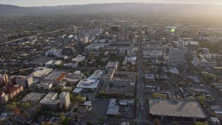 AX0174_0029 - 6K stock footage aerial video of tilting from urban homes to reveal Downtown San Jose at sunset, California