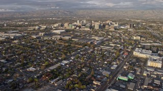AX0174_0034 - 6K stock footage aerial video of tilting from urban homes to reveal Downtown San Jose at sunset, California