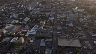 AX0174_0039 - 6K stock footage aerial video of a reverse view of city street and office and apartment buildings in Downtown San Jose at sunset, California