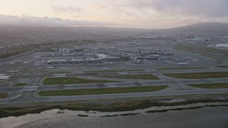 AX0174_0066 - 6K aerial stock footage of approaching San Francisco International Airport at sunset, California
