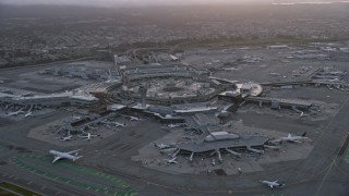 AX0174_0067 - 6K aerial stock footage of flying by and away from San Francisco International Airport at sunset, California