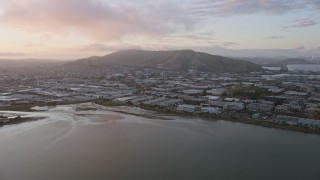 AX0174_0068 - 6K aerial stock footage of approaching South San Francisco office and warehouse buildings at sunset, California