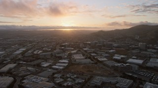 AX0174_0069 - 6K aerial stock footage of the setting sun behind South San Francisco office buildings, California