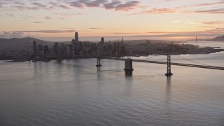 AX0174_0087 - 6K aerial stock footage a wide view of the Bay Bridge and the Downtown San Francisco skyline at sunset, California