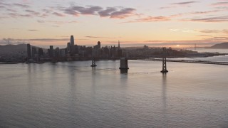 AX0174_0088 - 6K stock footage aerial video of the Bay Bridge and the Downtown San Francisco skyline at sunset, California