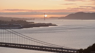 AX0174_0089 - 6K aerial stock footage of the Golden Gate Bridge and setting sun, seen from the Bay Bridge, California
