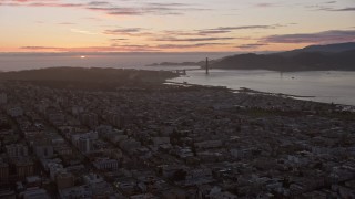 AX0174_0093 - 6K aerial stock footage of flying over the city toward the Golden Gate Bridge and setting sun, San Francisco, California