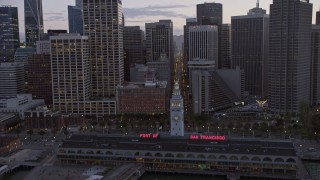AX0174_0100 - 6K stock footage aerial video tilt from the bay to reveal and fly over Downtown San Francisco skyscrapers at twilight, California