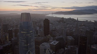 AX0174_0104 - 6K stock footage aerial video fly over Downtown San Francisco toward distant Golden Gate Bridge at twilight, California