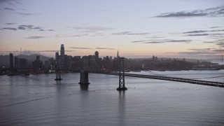 AX0174_0113 - 6K aerial stock footage fly away from Downtown San Francisco skyline, seen from Bay Bridge at twilight, California