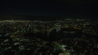 AX0174_0126 - 6K aerial stock footage of approaching Downtown Oakland and Lake Merritt at night, California