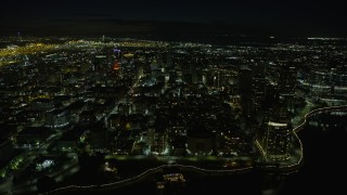 AX0174_0127 - 6K aerial stock footage of approaching Downtown Oakland office buildings from Lake Merritt at night, California