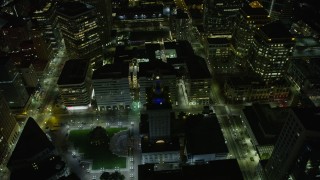 AX0174_0128 - 6K aerial stock footage of approaching and flying by Oakland City Hall in Downtown Oakland at night, California