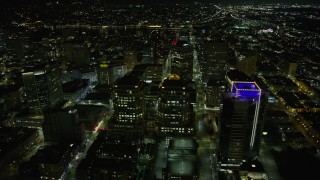 AX0174_0129 - 6K stock footage aerial video of flying by Oakland City Hall and government office building in Downtown Oakland at night, California