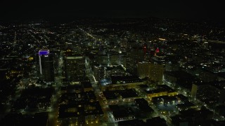 AX0174_0130 - 6K aerial stock footage of flying by office buildings in Downtown Oakland at night, California