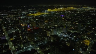 AX0174_0135 - 6K aerial stock footage fly over office buildings in Downtown Oakland, approach the port at night, California